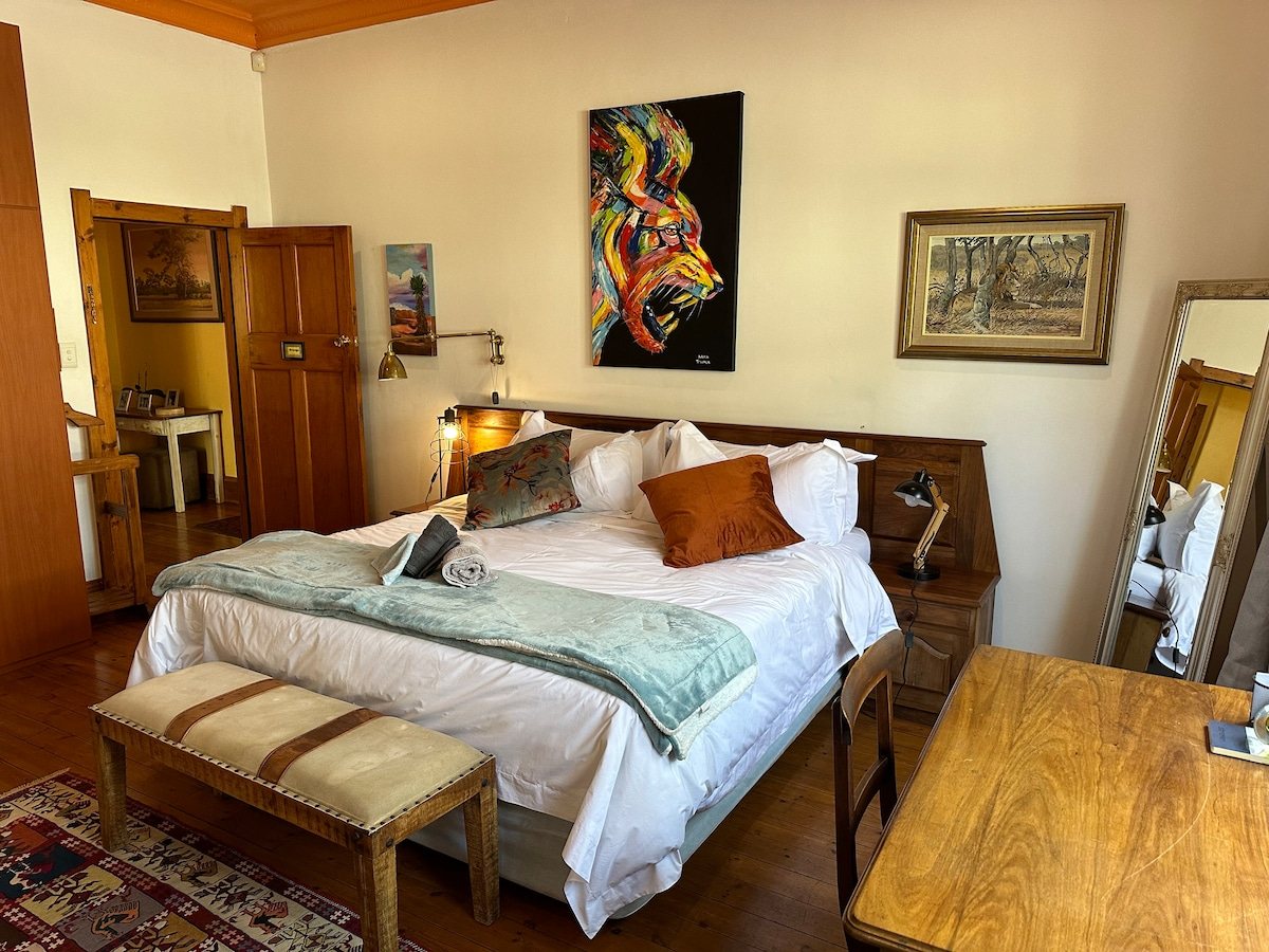 Urban Tiger guest suite — king bed, red chairs, and a work desk